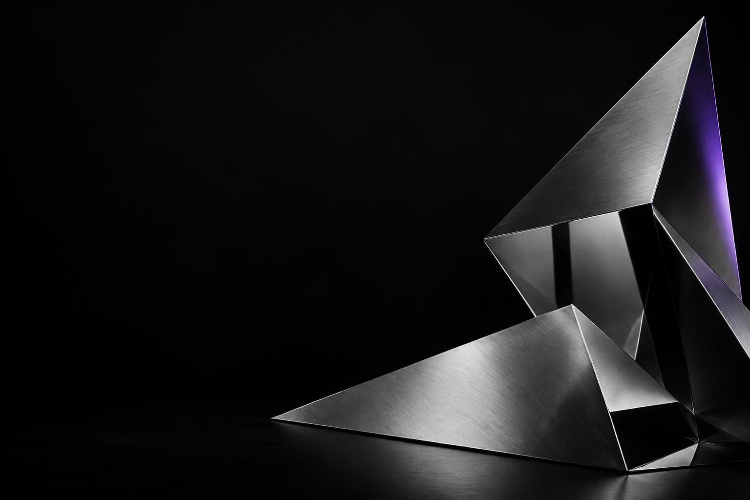 Angular brushed-metal sculpture against a dark background